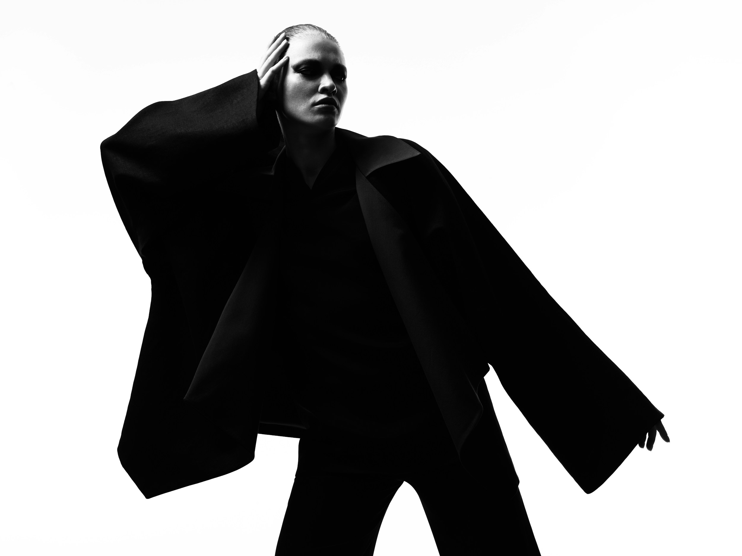 Two women sitting at a modern table talking with a city view behind them.